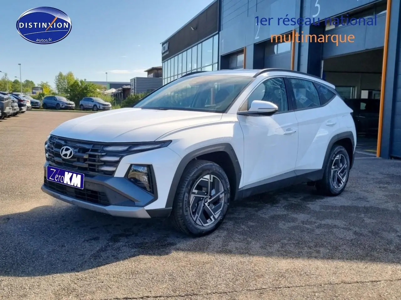 Hyundai Tucson blanc atlas en 3/4 avant droit, avec calandre grise et jantes alliage 17 pouces distinctives.