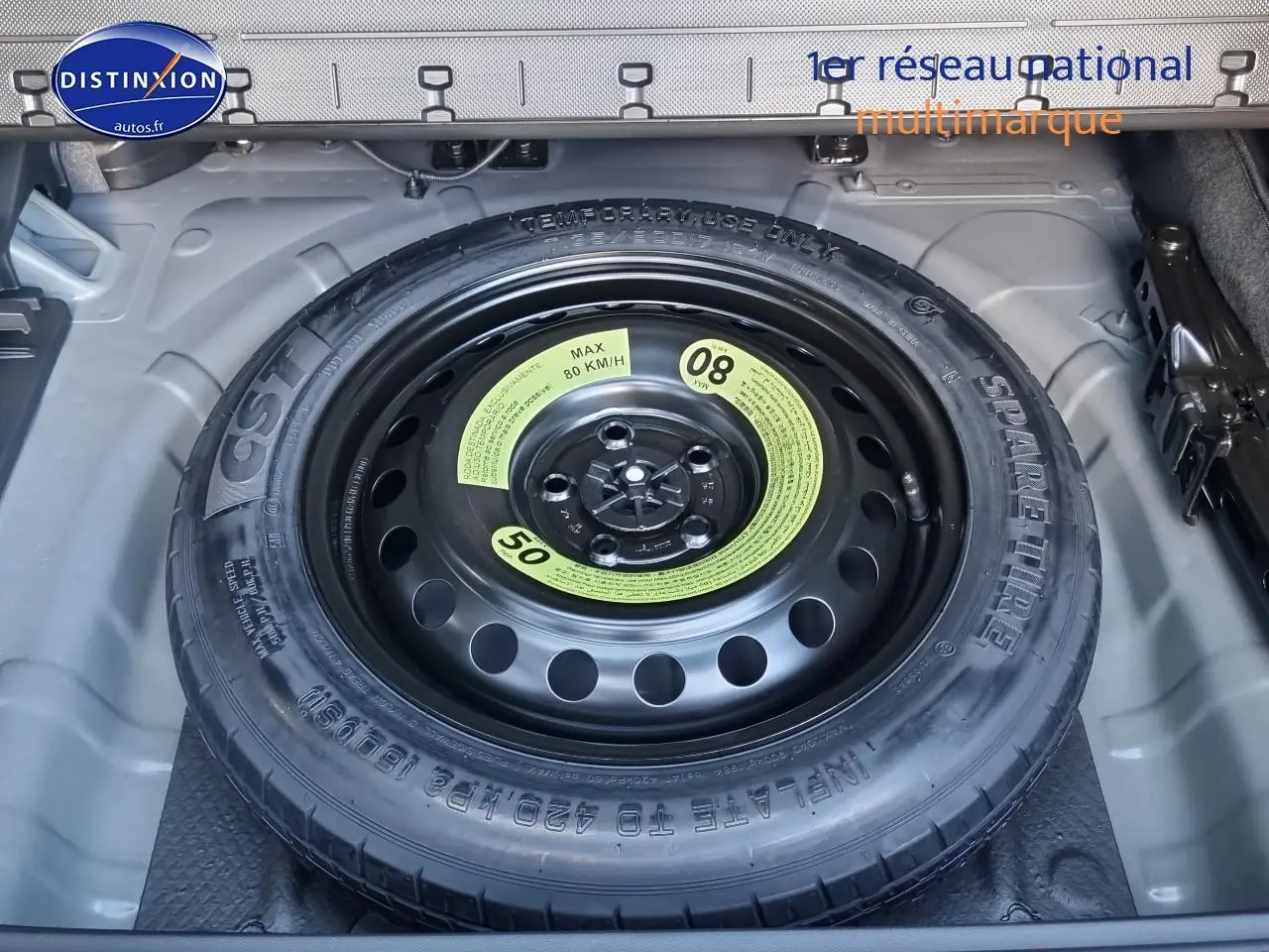 Roue de secours en gros plan dans le coffre d'un Hyundai Tucson blanc atlas 2025 hybride essence.