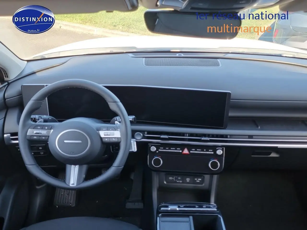 Vue intérieure du tableau de bord et volant cuir noir du Hyundai Tucson 2025 hybride essence, avec écran tactile panoramique.