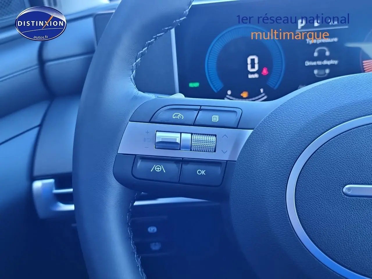 Gros plan sur le volant cuir du Hyundai Tucson 2025 avec commandes multifonctions et tableau de bord numérique.