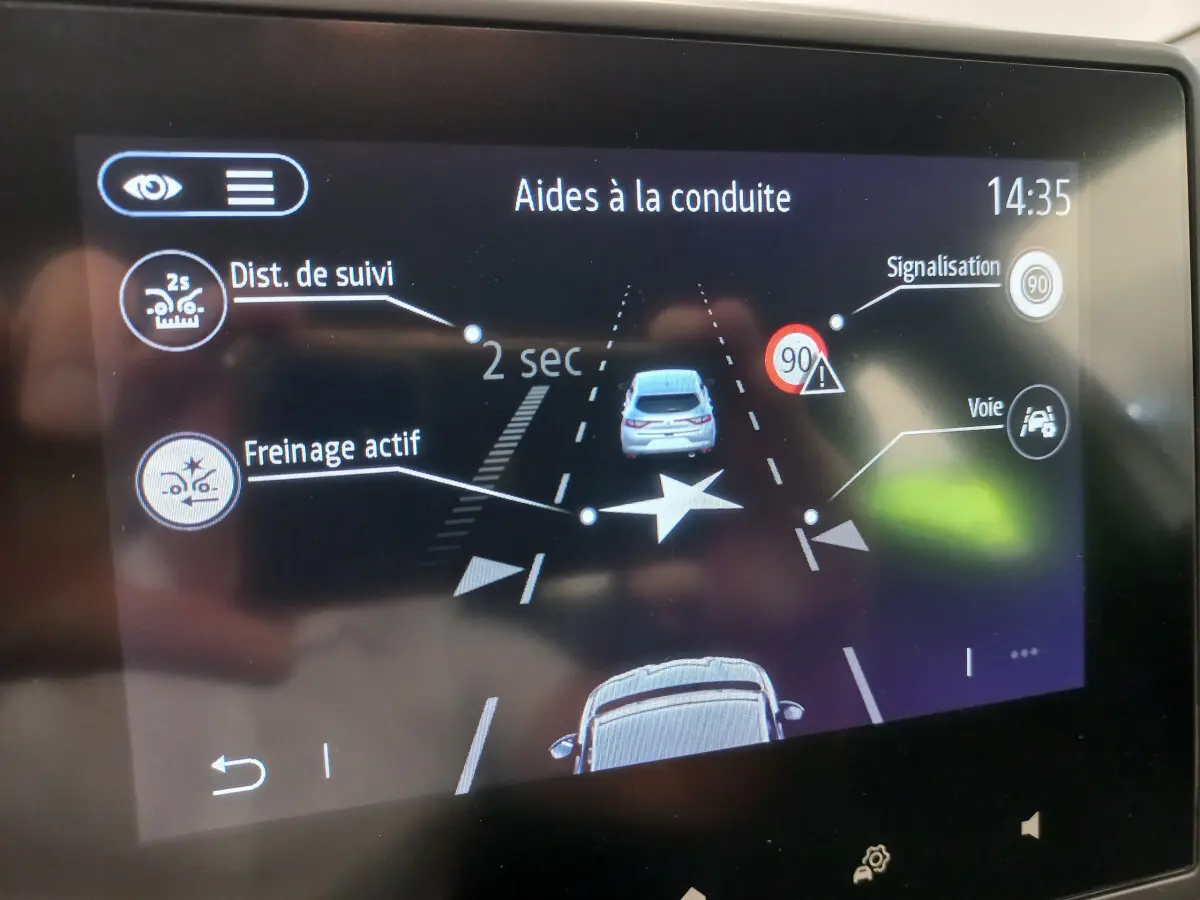 Écran tactile de la Renault Clio Business blanc montrant l'aide à la conduite avec freinage actif et signalisation 90 km/h.