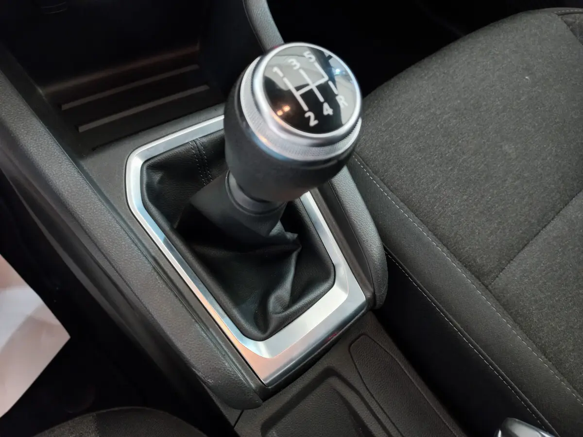 Gros plan sur le levier de vitesses manuel noir et argenté de la Renault Clio Business blanche, côté console centrale.