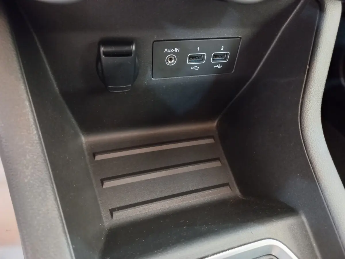 Gros plan sur la console centrale noire de la Renault Clio Business avec ports USB et prise Aux-In visibles.