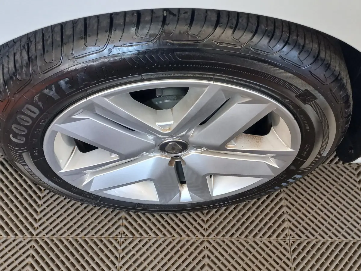 Gros plan sur la roue avant droite blanche d'une Renault Clio Business SCe 65 avec jante alliage et pneu Goodyear.