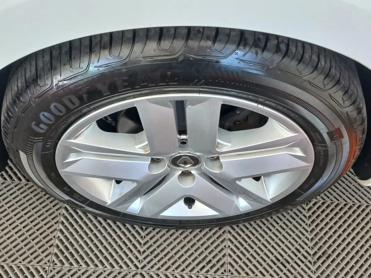 Gros plan sur la roue avant droite d'une Renault Clio Business blanche, jante alliage et pneu Goodyear visibles.