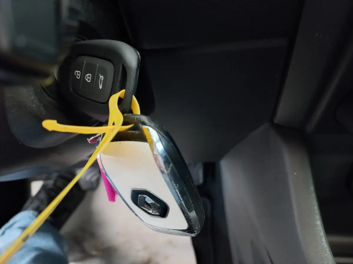 Gros plan sur la clé blanche Renault suspendue près du tableau de bord noir côté conducteur d'une Clio Business 2021.