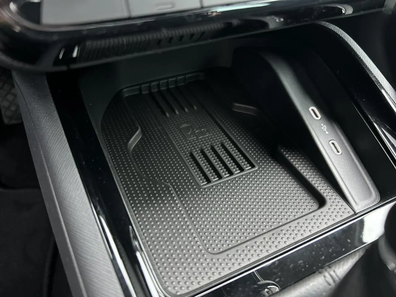 Gros plan sur le chargeur à induction et ports USB-C dans la console centrale du Skoda Kamiq gris graphite 2025.