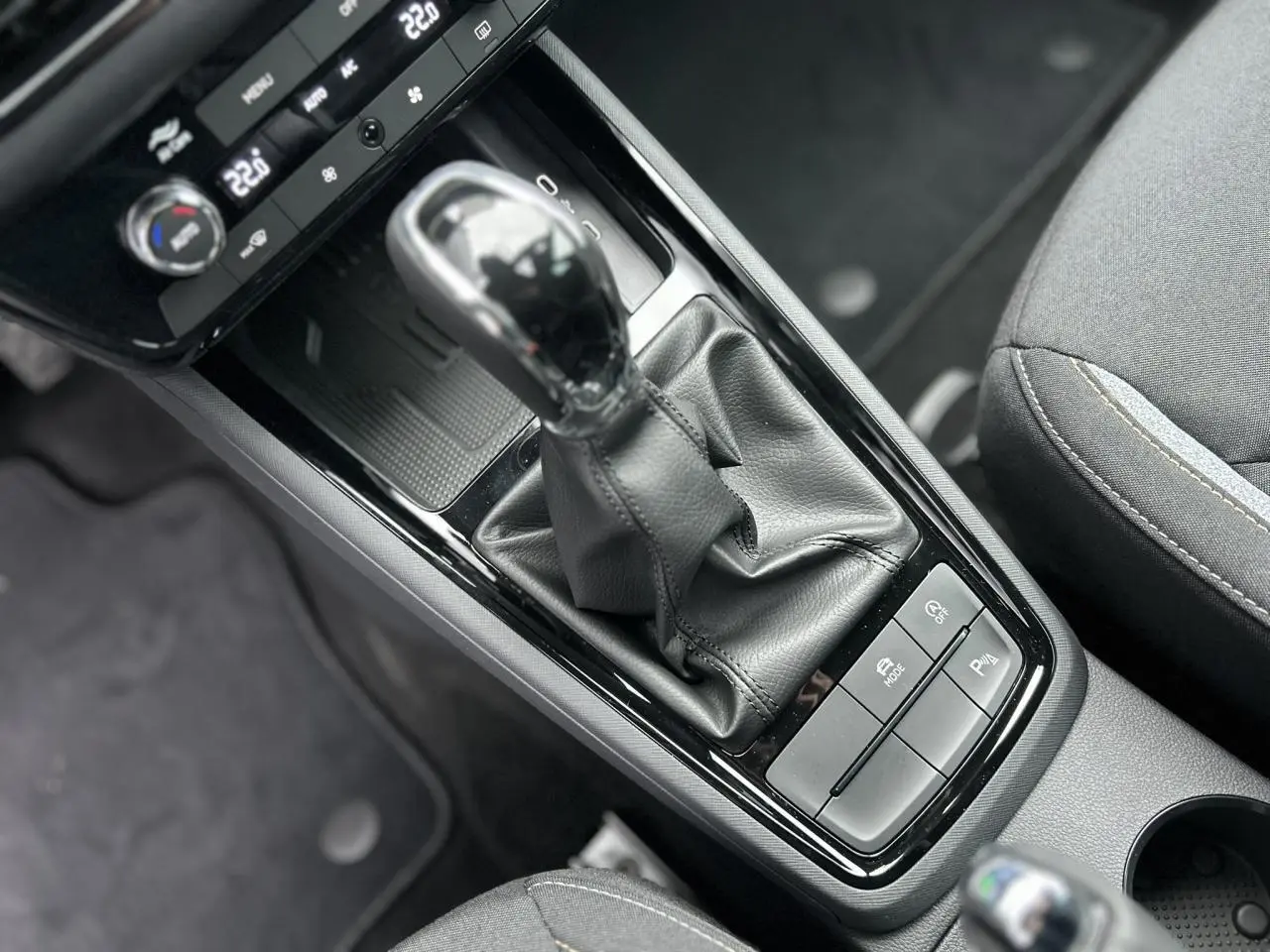 Gros plan sur la console centrale du Skoda Kamiq gris graphite, mettant en valeur le levier de vitesses automatique et les commandes.