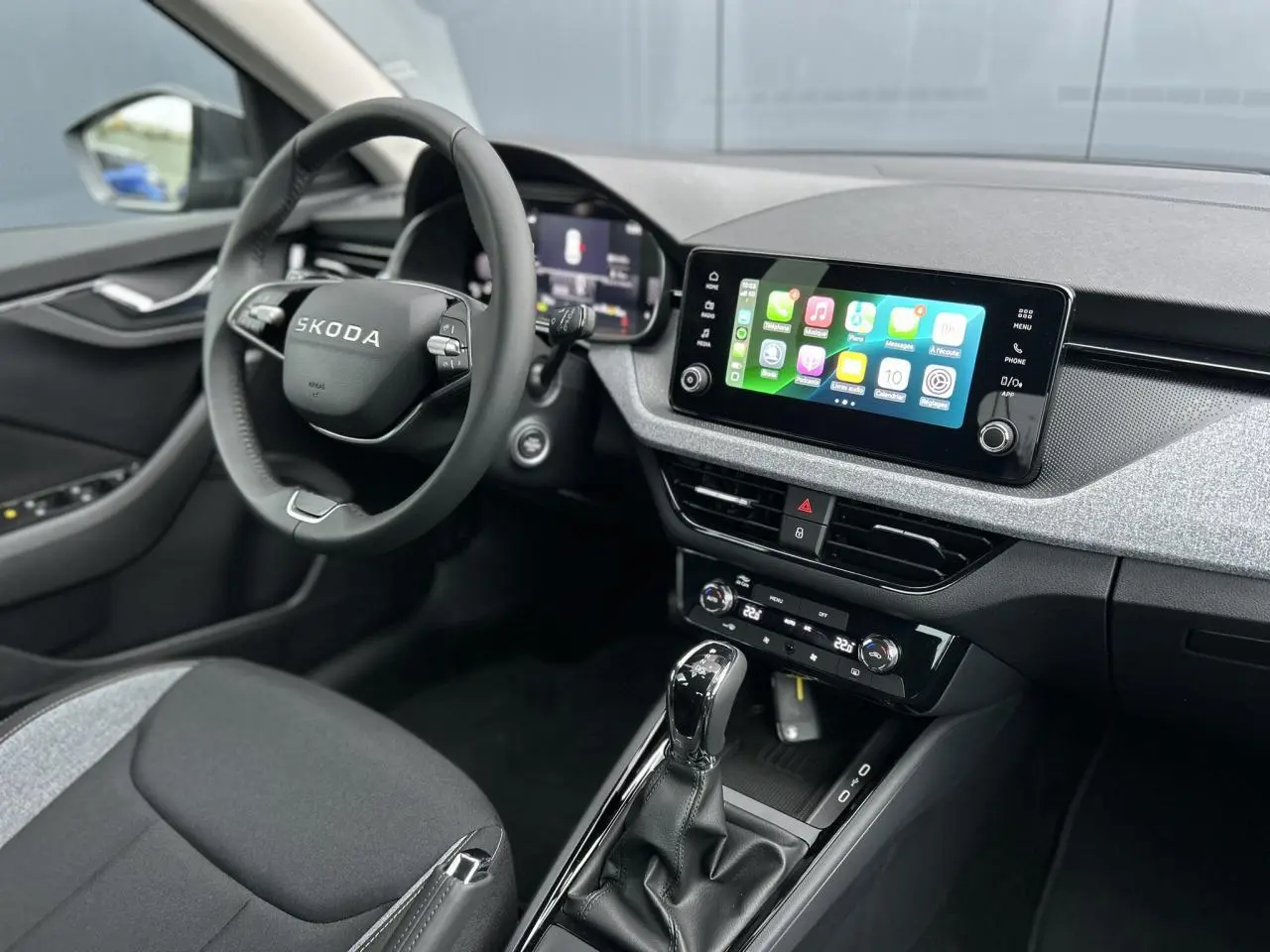 Vue intérieure côté conducteur du Skoda Kamiq gris graphite, avec volant multifonctions et écran tactile Apple Car Play.