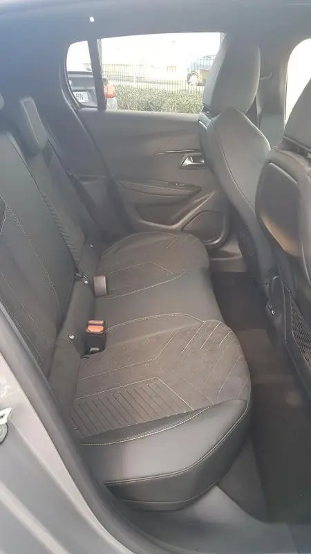 Vue latérale intérieure des sièges arrière gris de la Peugeot 208 Hybrid 110 e-DCS6 GT avec finitions en tissu et cuir.