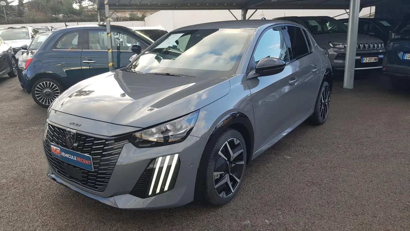 Peugeot 208 Hybrid gris vue 3/4 avant droit, feux diurnes verticaux allumés et jantes alliage 17 pouces.