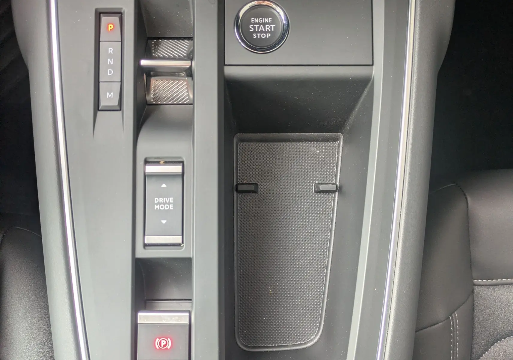 Vue plongeante sur la console centrale noire du Citroën C5 Aircross hybride 2025 avec bouton start/stop et commandes de boîte auto.