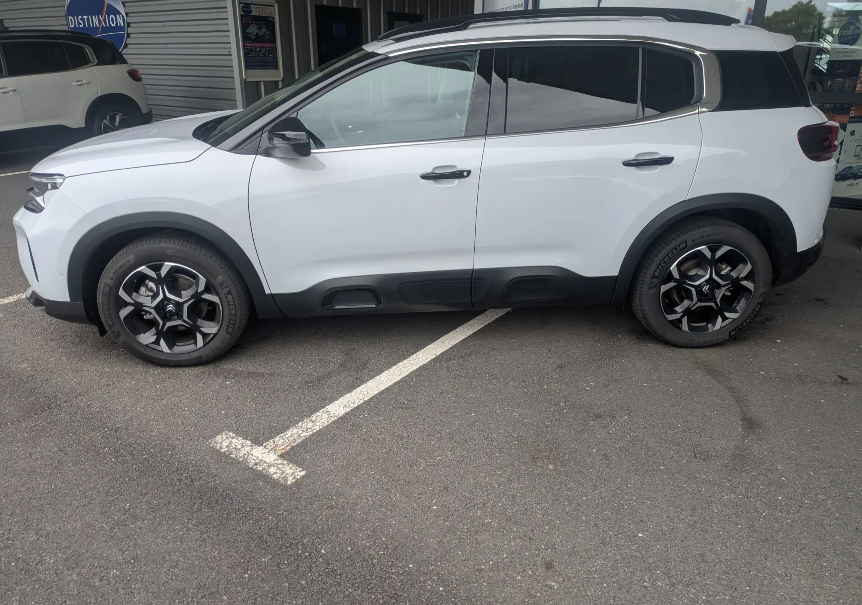 Profil droit d'un Citroën C5 Aircross hybride blanc Okenite avec jantes alliage 18 pouces biton et vitres arrière surteintées.