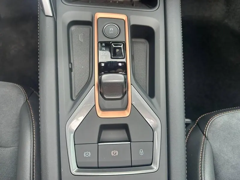 Vue plongeante sur la console centrale noire et cuivre du CUPRA Formentor 2.0 TDI avec commandes de boîte auto et boutons fonctionnels.