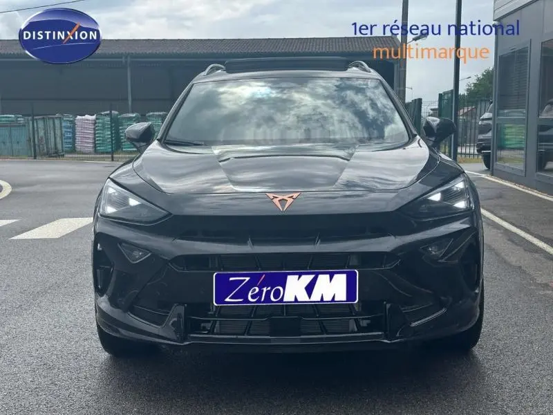 Vue avant d'une CUPRA Formentor noir minuit métallisé avec logo cuivré et phares LED allumés sur parking.