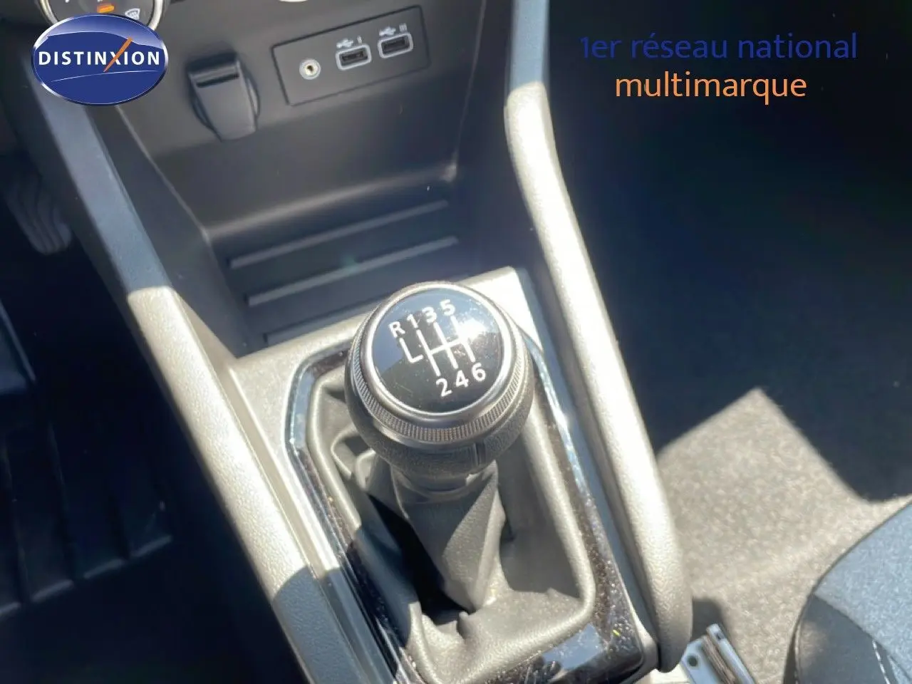 Gros plan sur le levier de vitesses manuel de la Renault Clio 2025, intérieur tissu noir avec connectiques USB visibles.