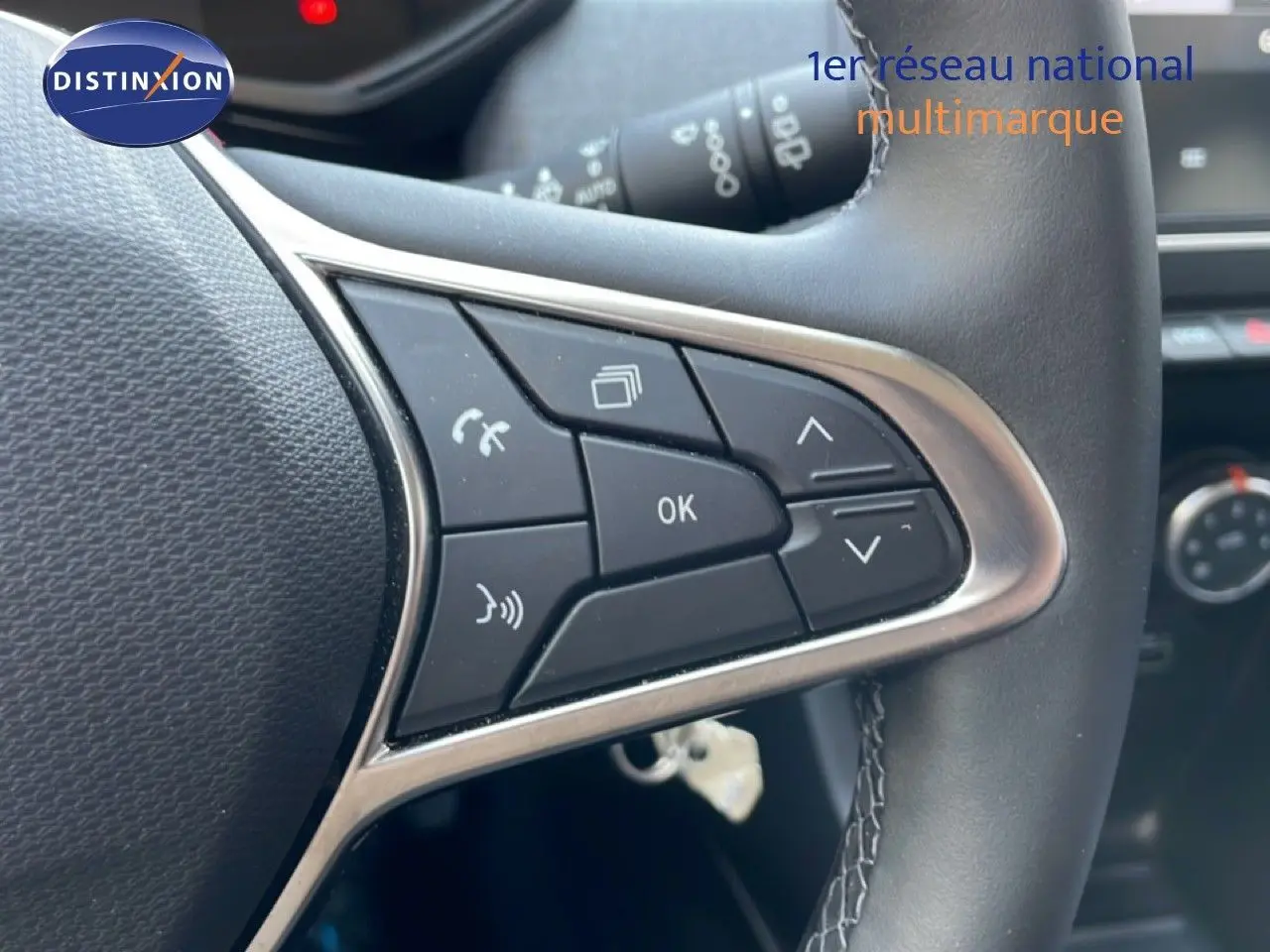 Gros plan sur les commandes multifonctions à droite du volant en cuir noir d'une Renault Clio 2025.
