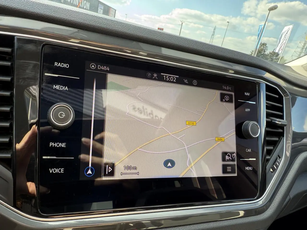 Écran tactile central du Volkswagen T-Roc blanc 2022 affichant la navigation, vue intérieure côté conducteur.