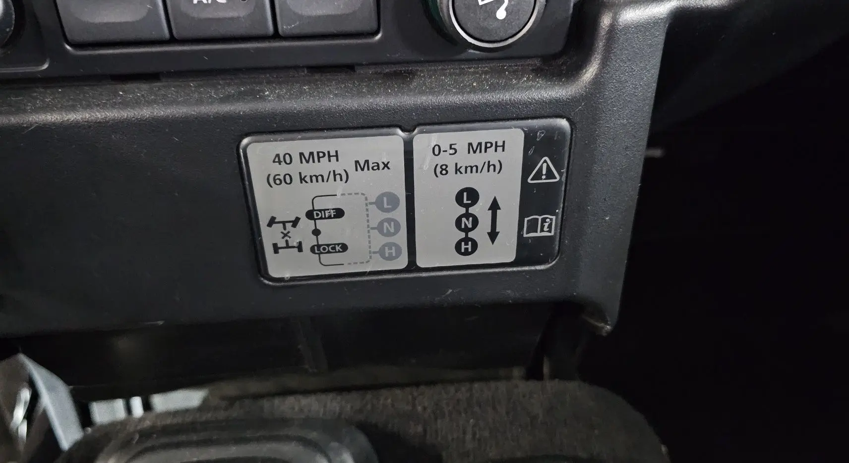 Gros plan sur l'autocollant des vitesses de transfert du Land Rover Defender 110 II gris, version Station Wagon S de 2010.