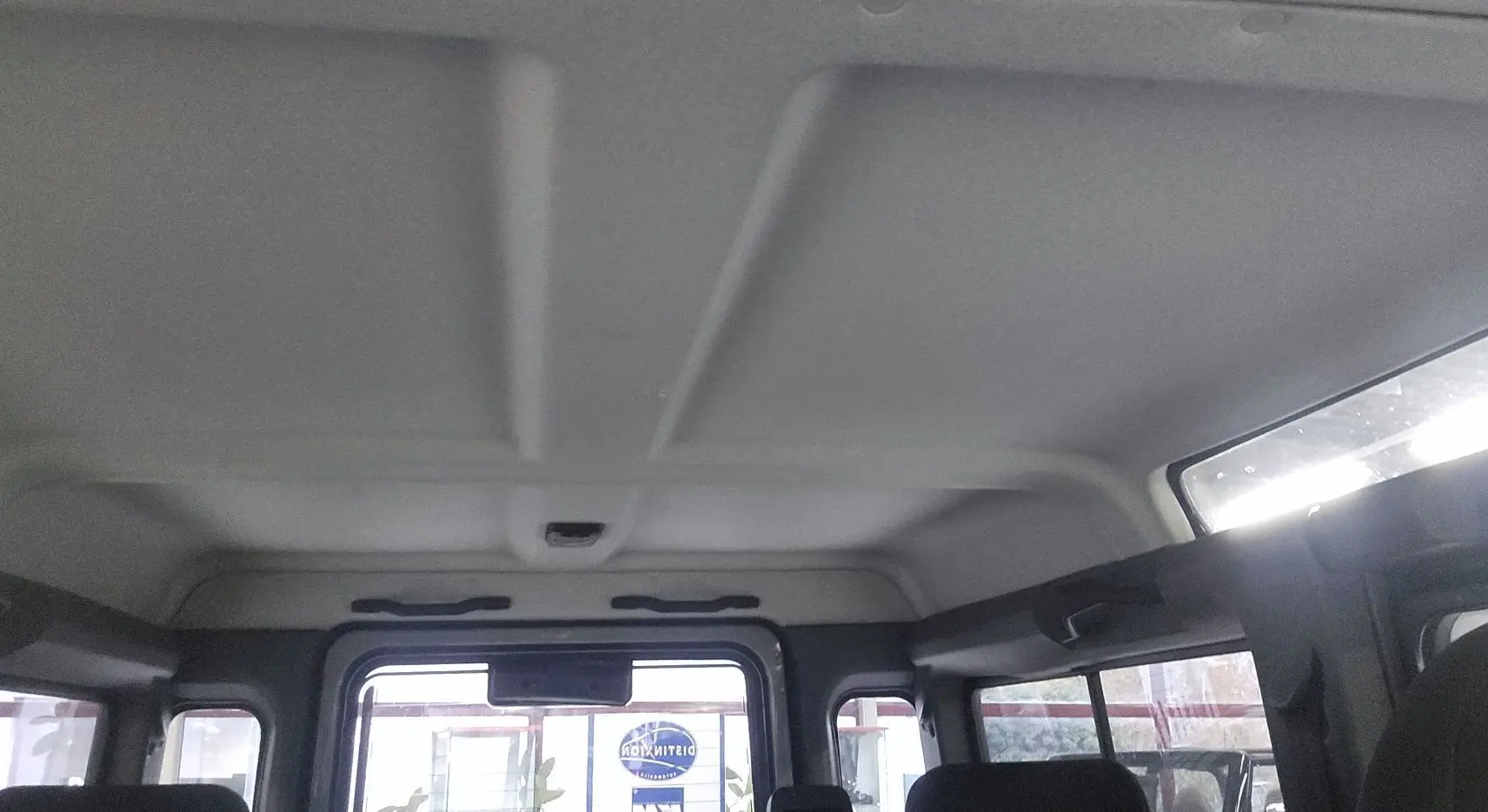 Intérieur du toit et des fenêtres arrière d'un Land Rover Defender 110 II Station Wagon gris, vue depuis l'arrière vers l'avant.