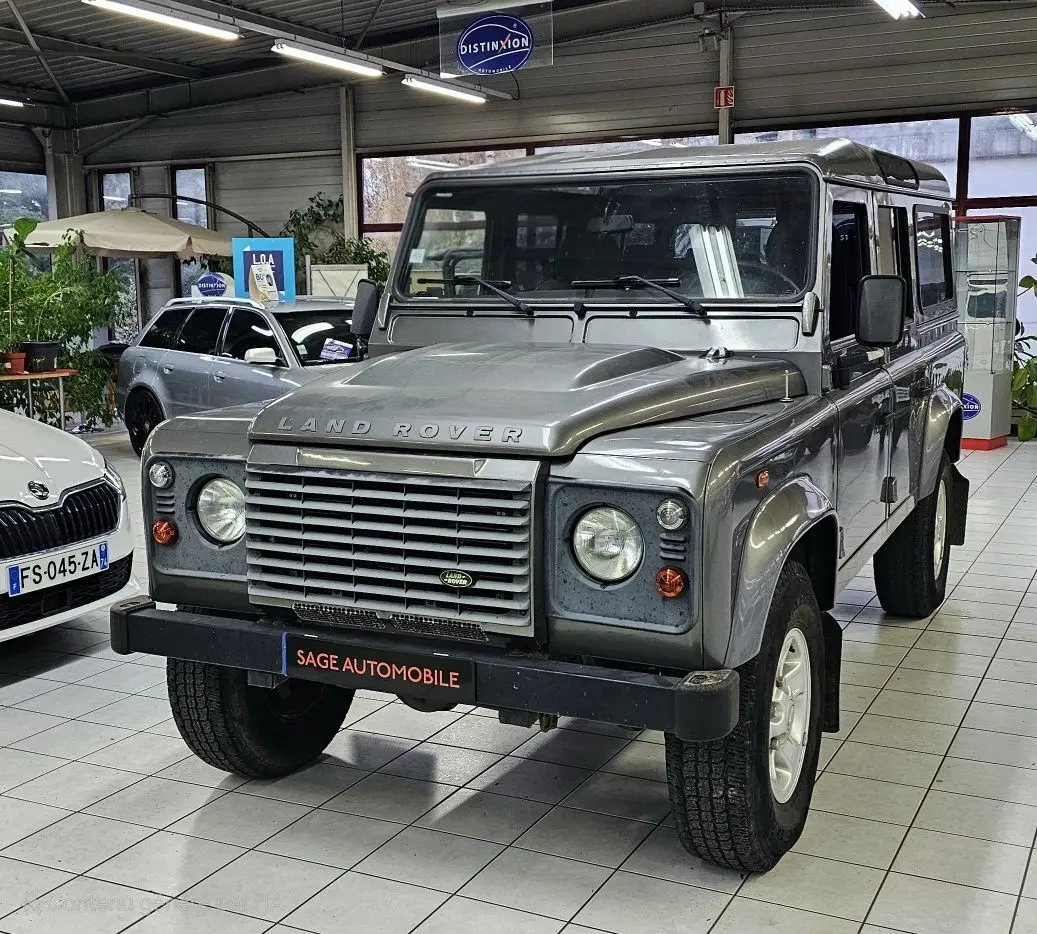 Vue 3/4 avant droit d'un Land Rover Defender 110 Station Wagon S gris diesel de 2010 en showroom.