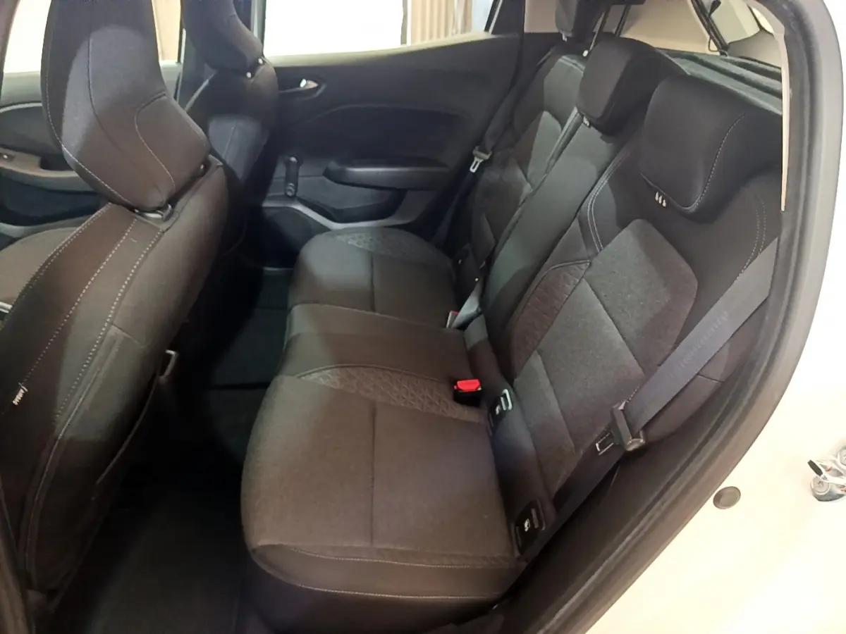 Vue intérieure sur la banquette arrière noire de la Renault Clio Business blanche, avec ceinture de sécurité visible côté droit.