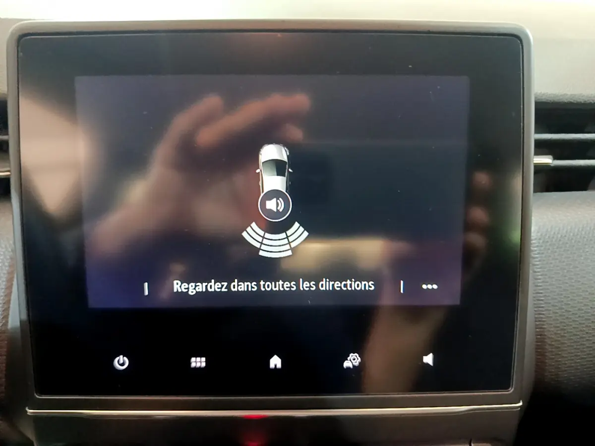 Écran tactile central de la Renault Clio Business blanc 2021 affichant l'alerte de détection d'obstacles.