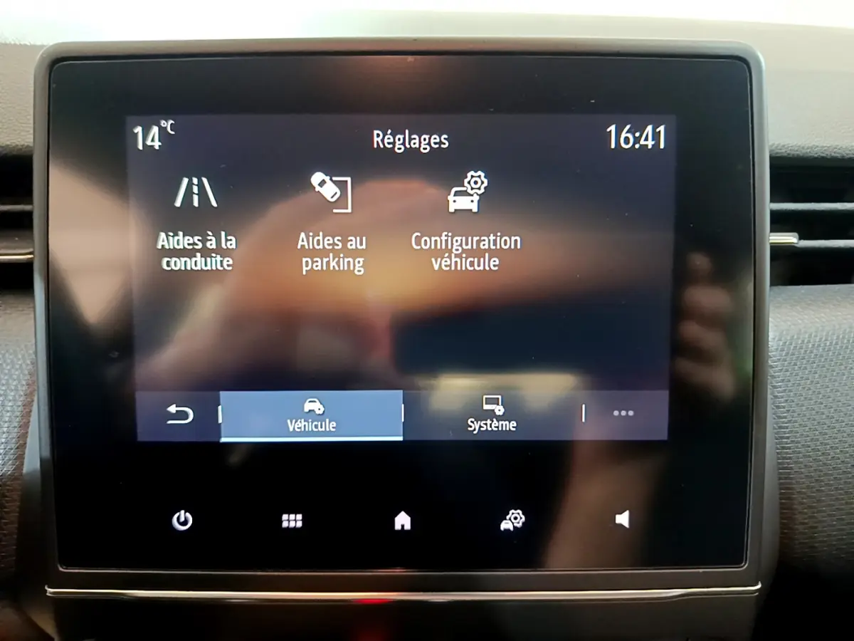 Écran tactile central de la Renault Clio Business blanc montrant les réglages d’aides à la conduite et parking