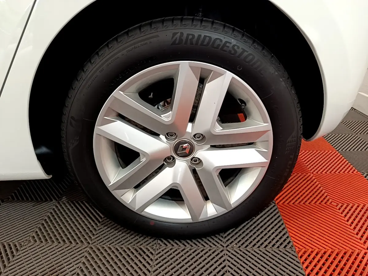 Gros plan sur la roue avant droite blanche d'une Renault Clio Business 2021 avec jante alliage et pneu Bridgestone.