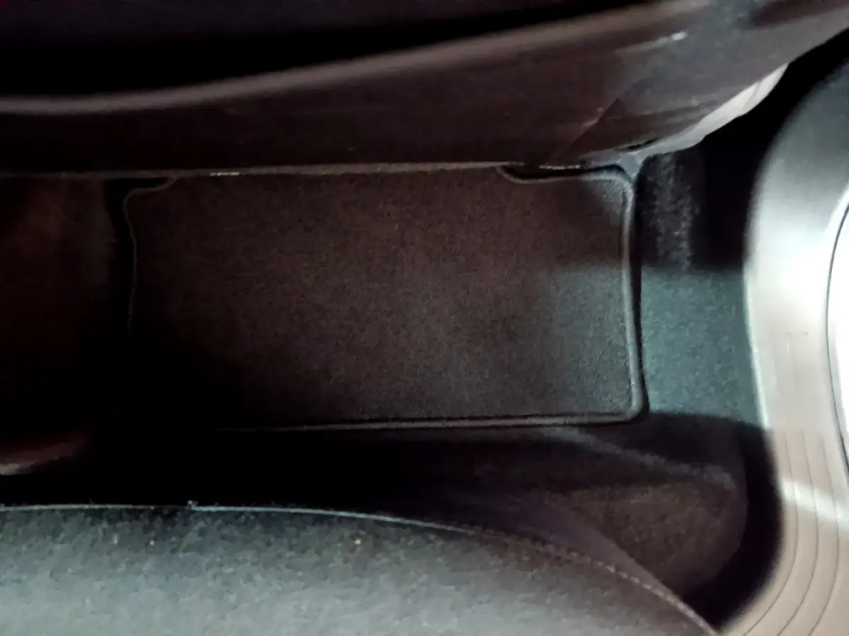 Tapis de sol noir côté conducteur de la Renault Clio Business blanche 2021 avec pédalier visible à droite.