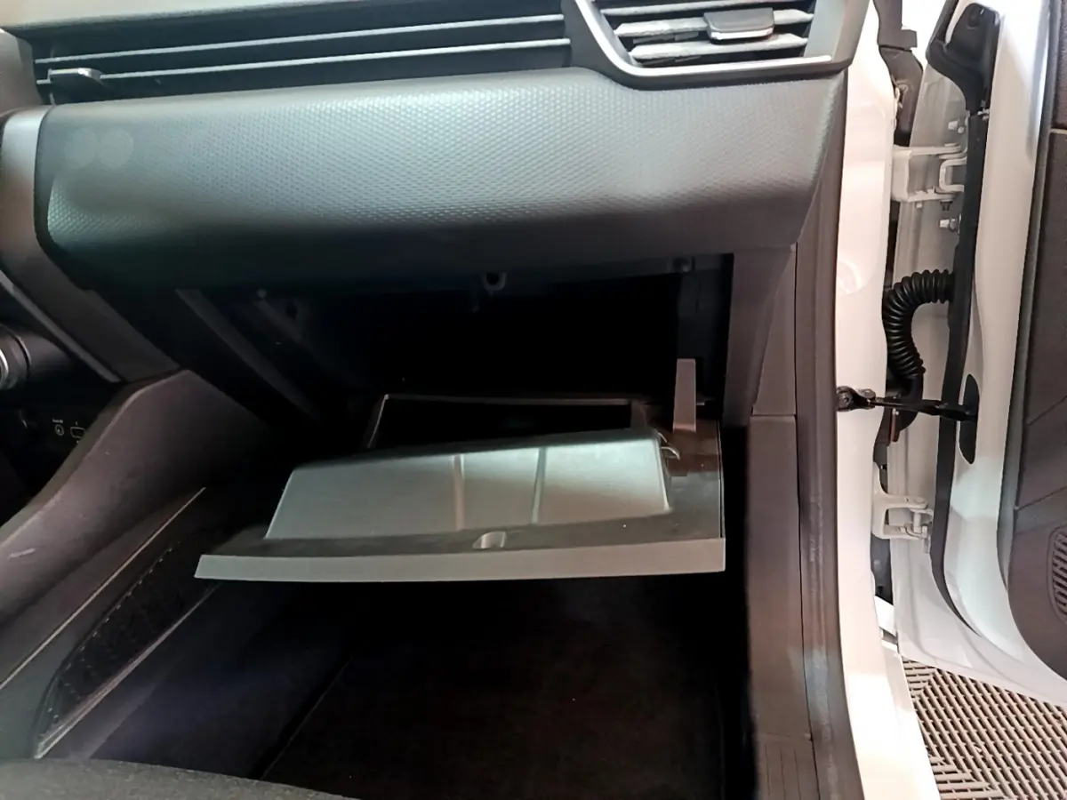Vue rapprochée de la boîte à gants ouverte côté passager d'une Renault Clio Business blanche de 2021.