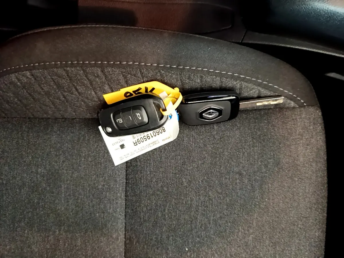 Clé Renault posée sur un siège tissu gris foncé, intérieur d'une Renault Clio Business SCe 65 de 2021.