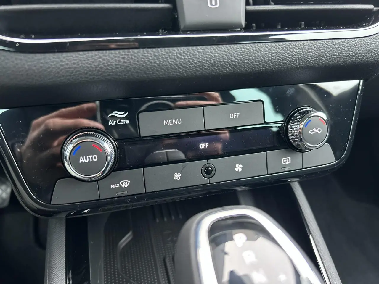 Gros plan sur la console centrale noire du Skoda Kamiq 2025, avec commandes climatisation automatique et levier de boîte auto.