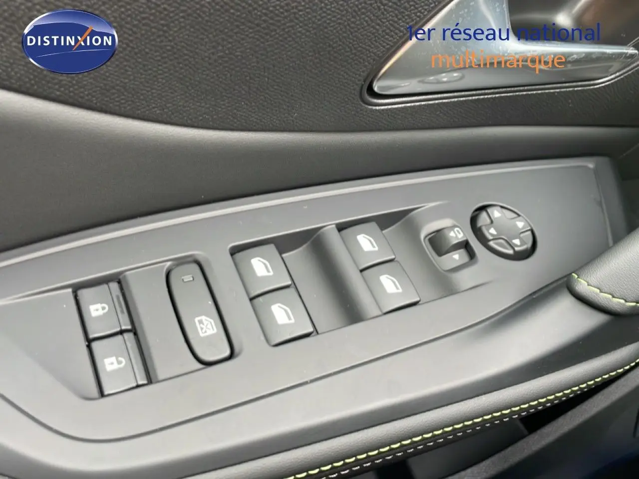 Détail des commandes de lève-vitres et rétroviseurs sur la portière côté gauche d’un Peugeot 308 gris Selenium 2026.