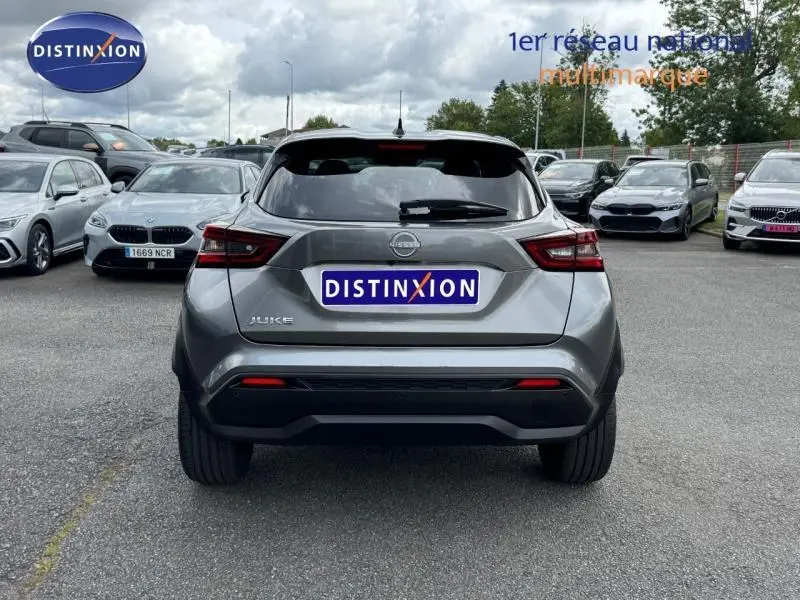Vue arrière d'un Nissan Juke 2025 gris métallisé stationné sur un parking multimarque.