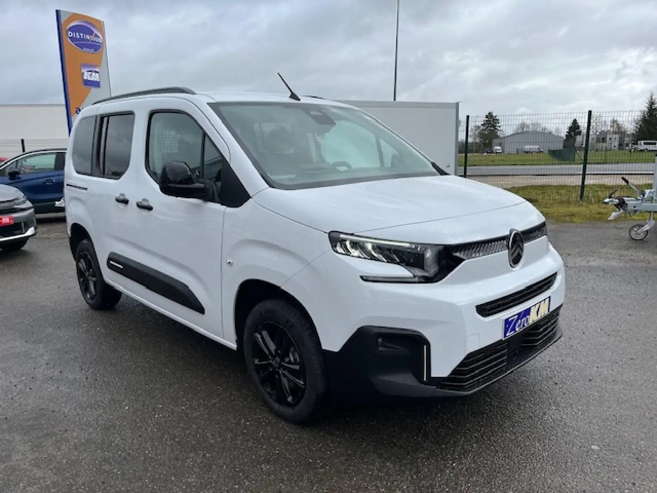 Vue 3/4 avant droite du Citroën Berlingo Multispace blanc 2025 avec jantes noires et calandre moderne.