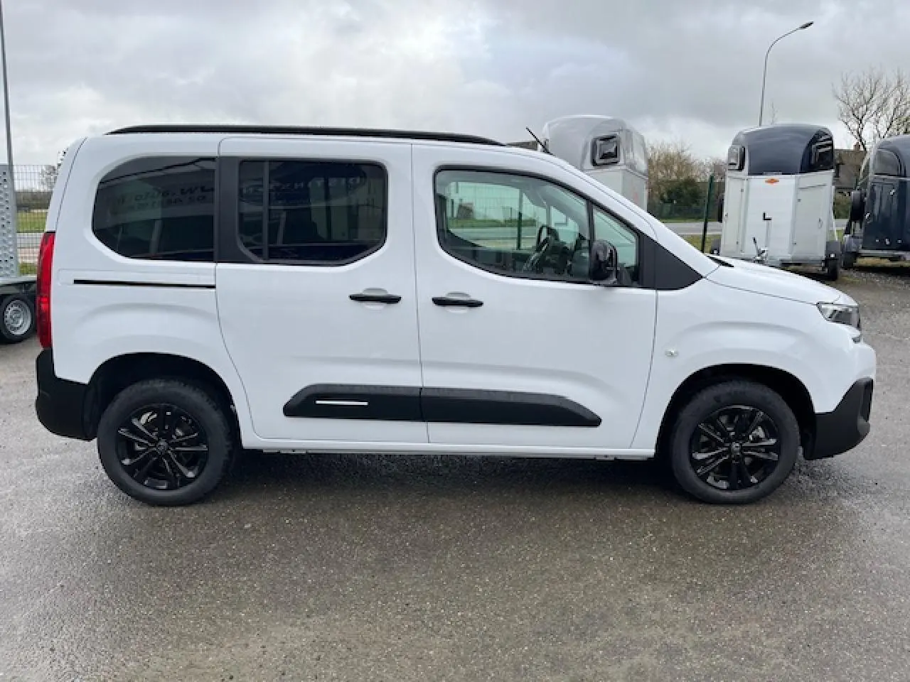 Vue latérale droite d'un Citroën Berlingo Multispace blanc 2025 avec jantes noires et vitres teintées.