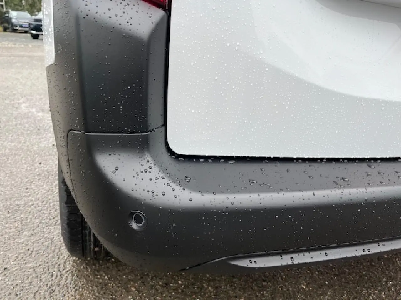 Gros plan sur l'angle arrière gauche du Citroën Berlingo Multispace blanc 2025, avec pare-chocs noir et capteur de recul.