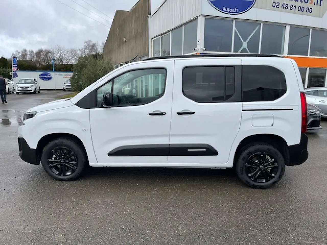 Vue de profil côté gauche d'un Citroën Berlingo Multispace blanc 2025 avec jantes noires et vitres teintées.