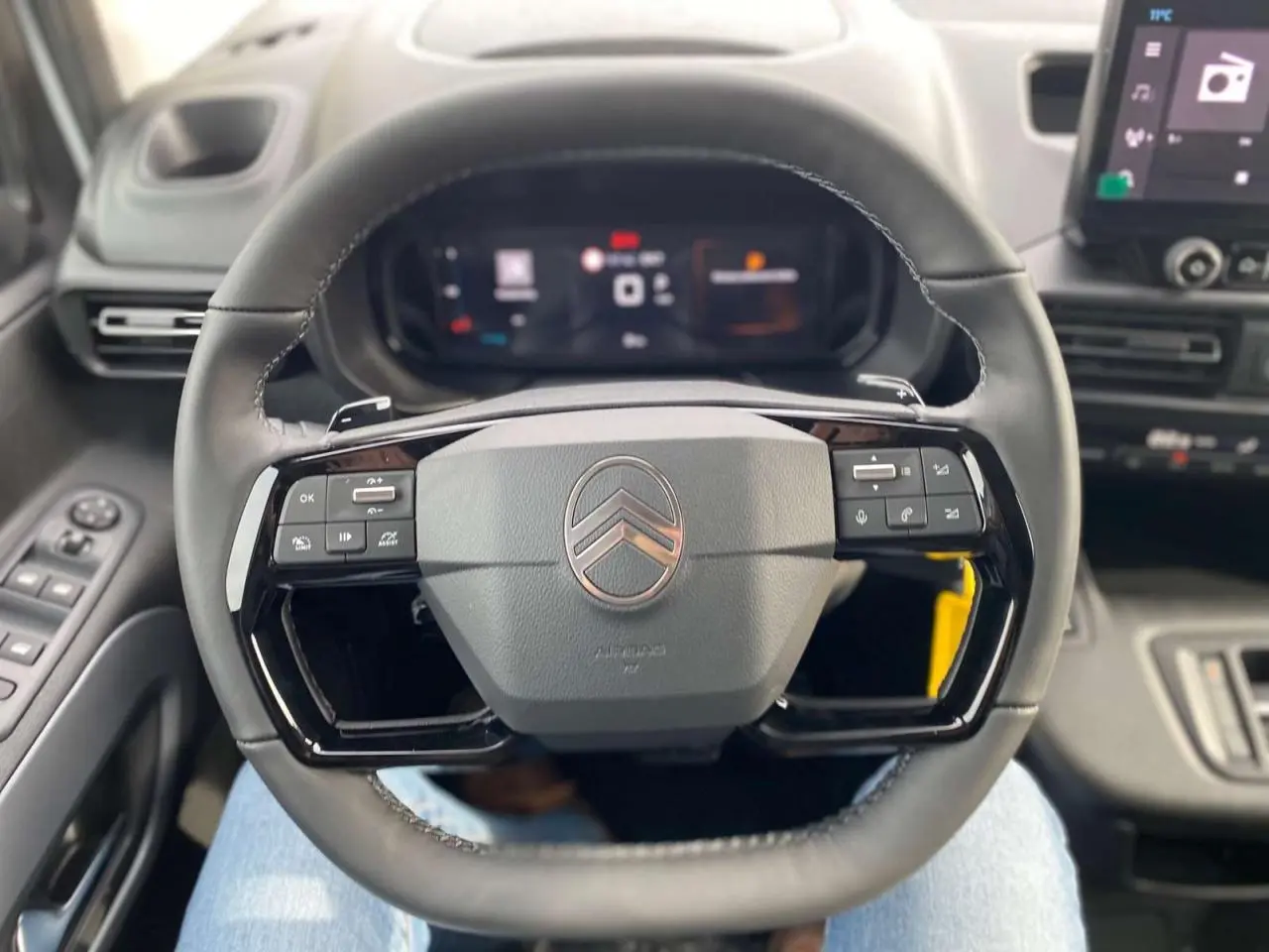 Vue rapprochée du volant noir du Citroën Berlingo Multispace 2025, avec commandes intégrées et tableau de bord numérique.