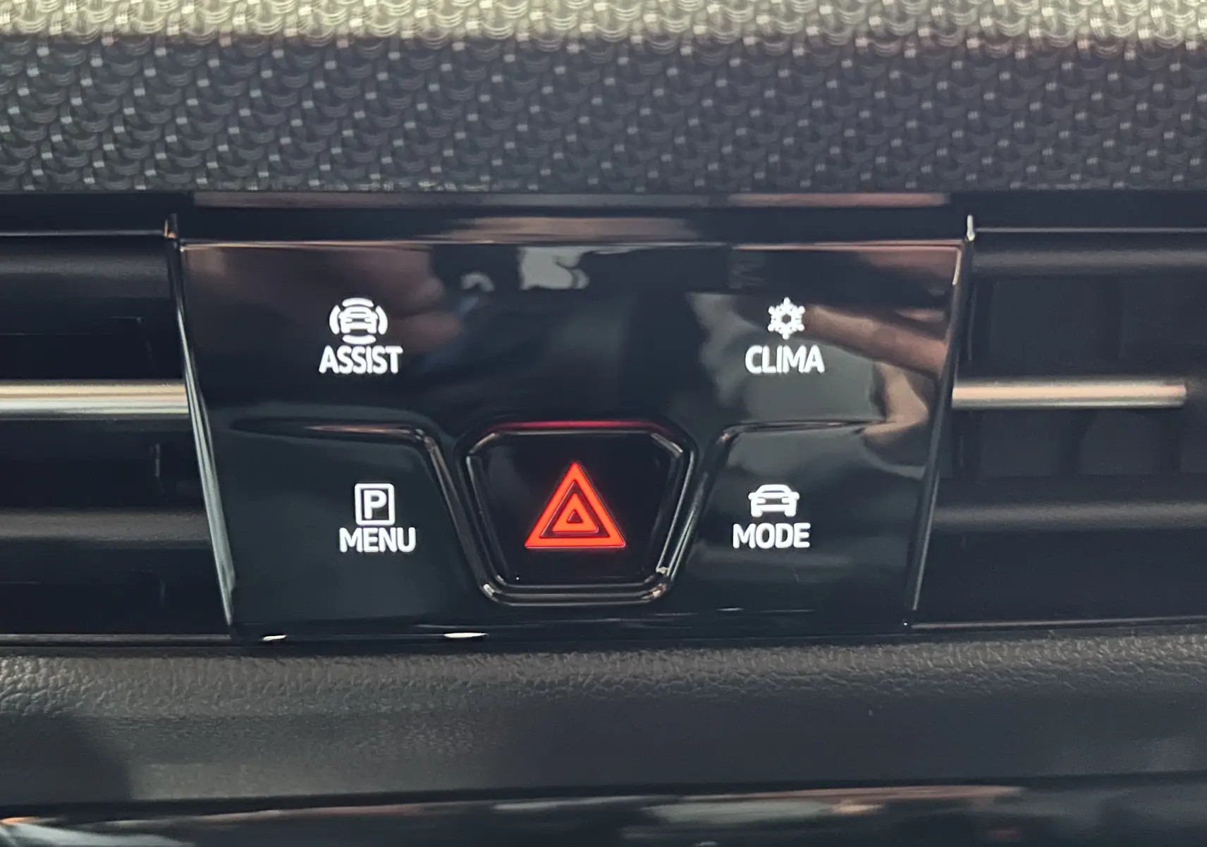 Détail du tableau de bord de la Volkswagen Golf VIII eTSI 150CH R-Line noir, montrant les boutons d'assistance, climatisation, menu et mode.