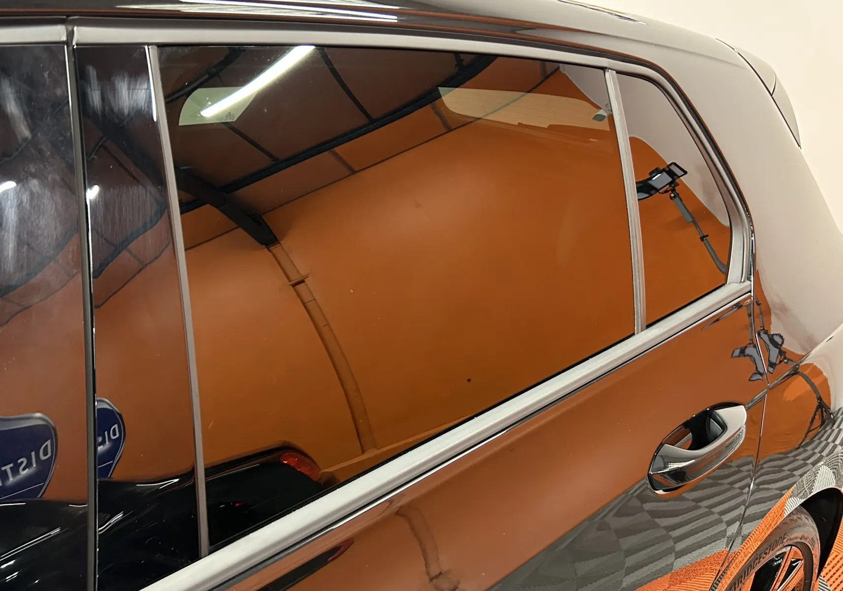 Vue latérale droite rapprochée d’une Volkswagen Golf VIII eTSI noire métal, soulignant la finition R-Line et les vitres teintées.