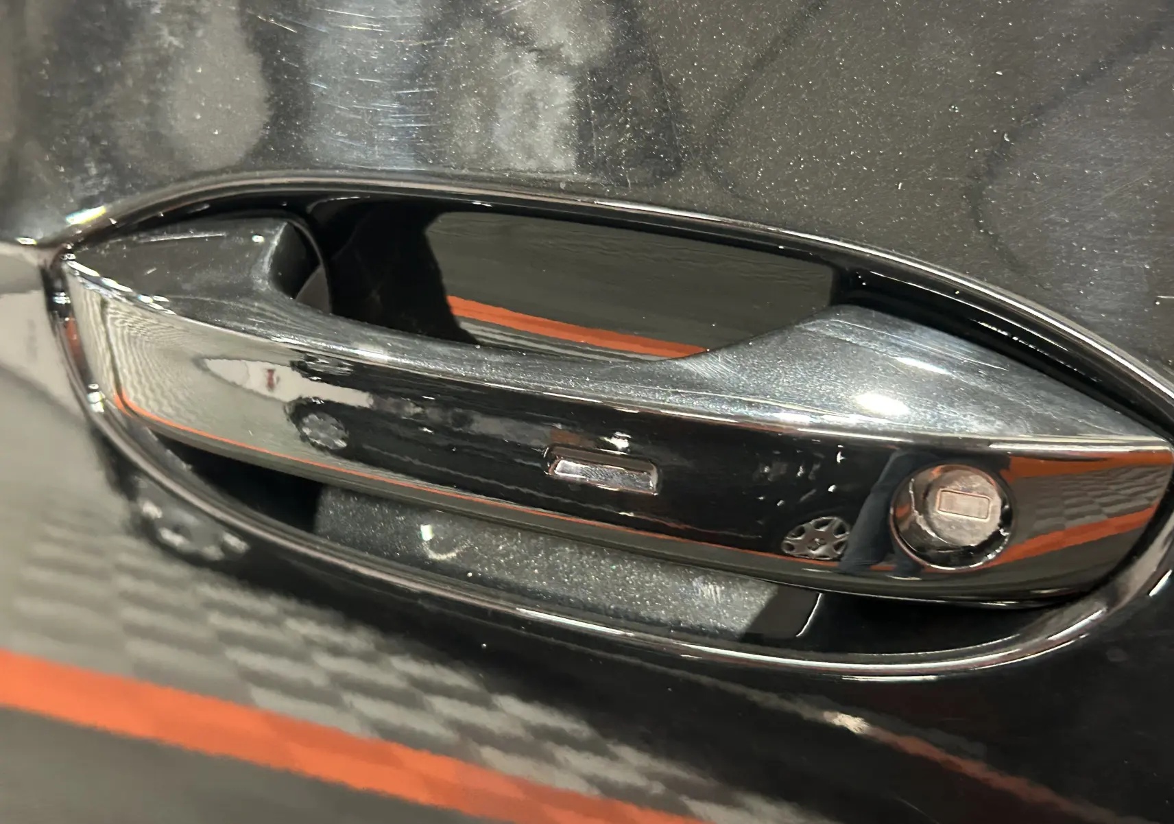 Poignée de porte noire métallisée en gros plan sur une Volkswagen Golf VIII eTSI 150CH R-Line 2024.