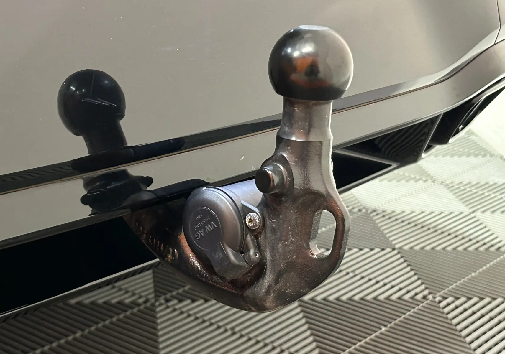 Gros plan sur l'attelage noir métallique d'une Volkswagen Golf VIII eTSI 150CH R-Line 2024, reflet sur la carrosserie.