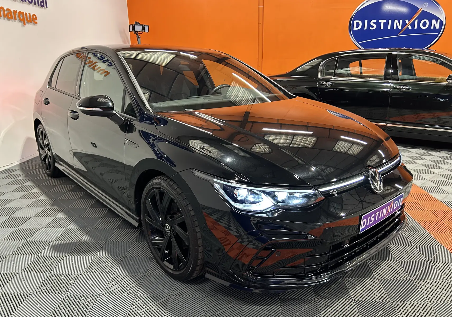 Volkswagen Golf VIII eTSI 150CH R-Line noir métal en 3/4 avant, phares LED allumés et jantes noires distinctives.