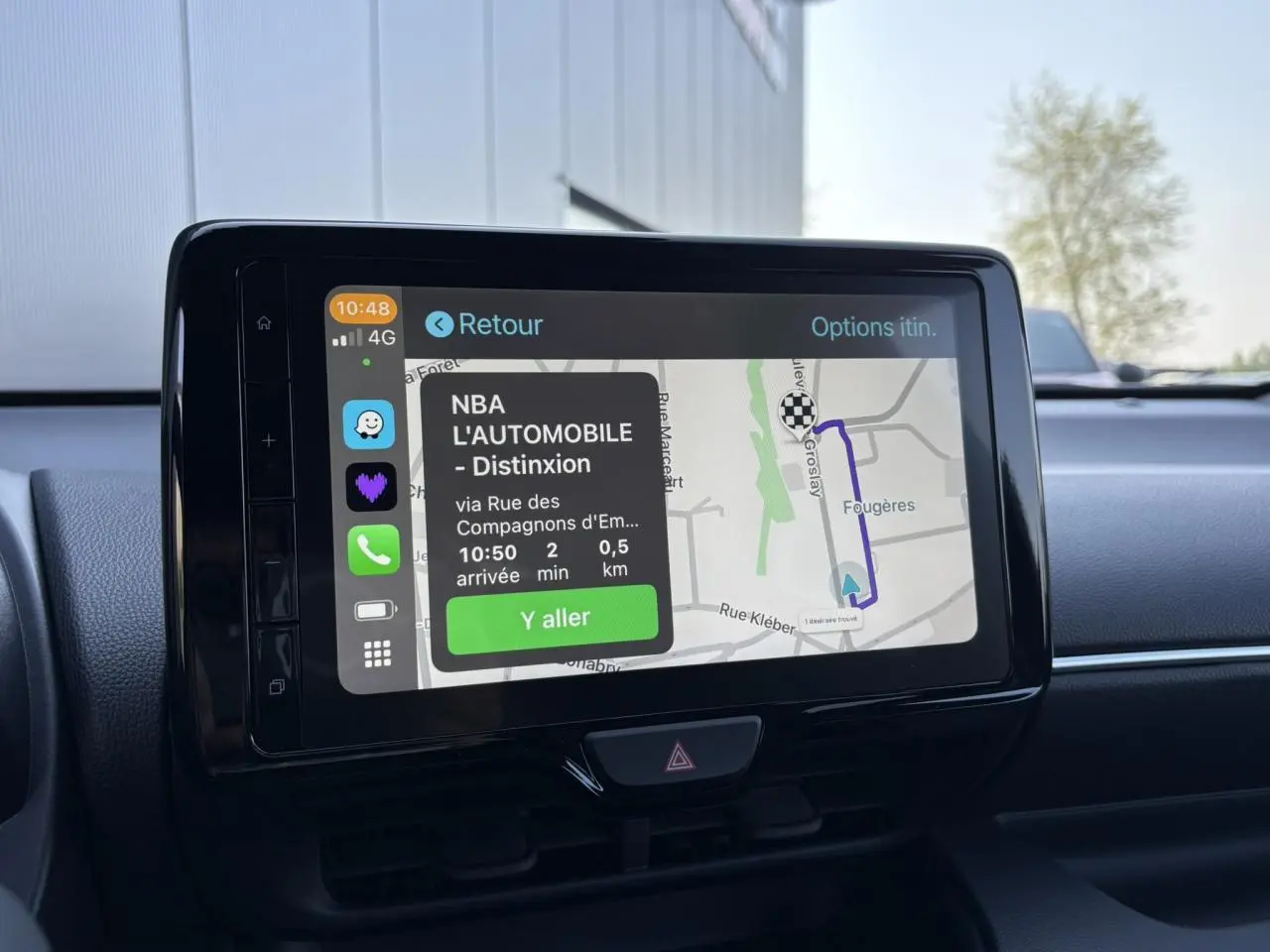 Écran tactile central de la Toyota Yaris hybride 2025 affichant un itinéraire GPS avec interface smartphone connectée.