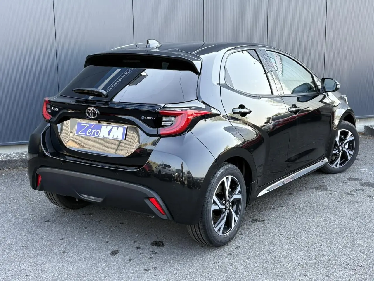 Vue 3/4 arrière droite d'une Toyota Yaris Hybride 2025 noir intense avec jantes alliage et vitres surteintées.