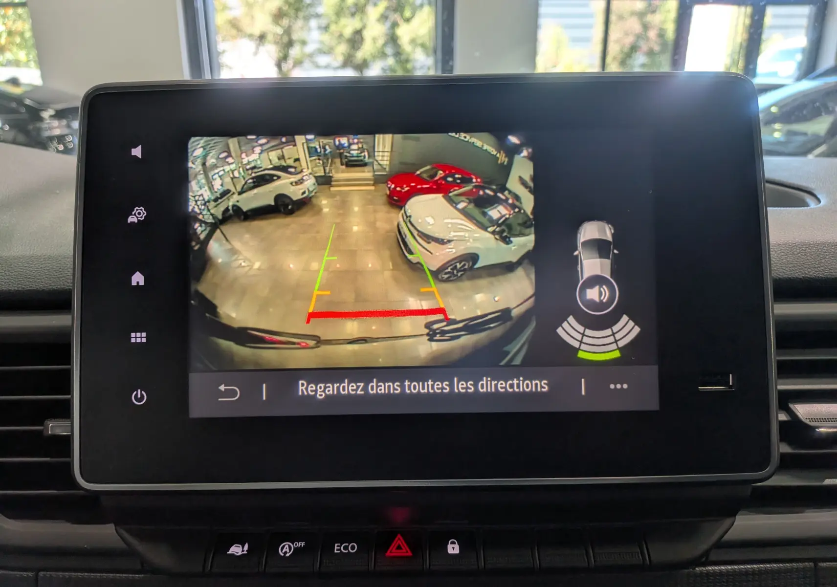 Écran de caméra de recul du Renault Trafic Combi gris, montrant l’arrière et les voitures en showroom.