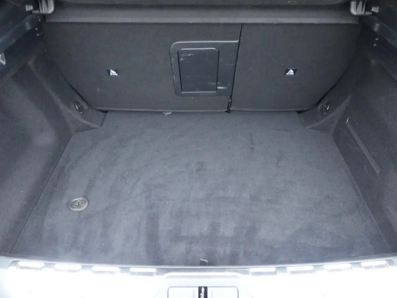 Coffre spacieux et propre du DS4 Cross Rivoli 2024, vu de face avec revêtement noir uniforme.