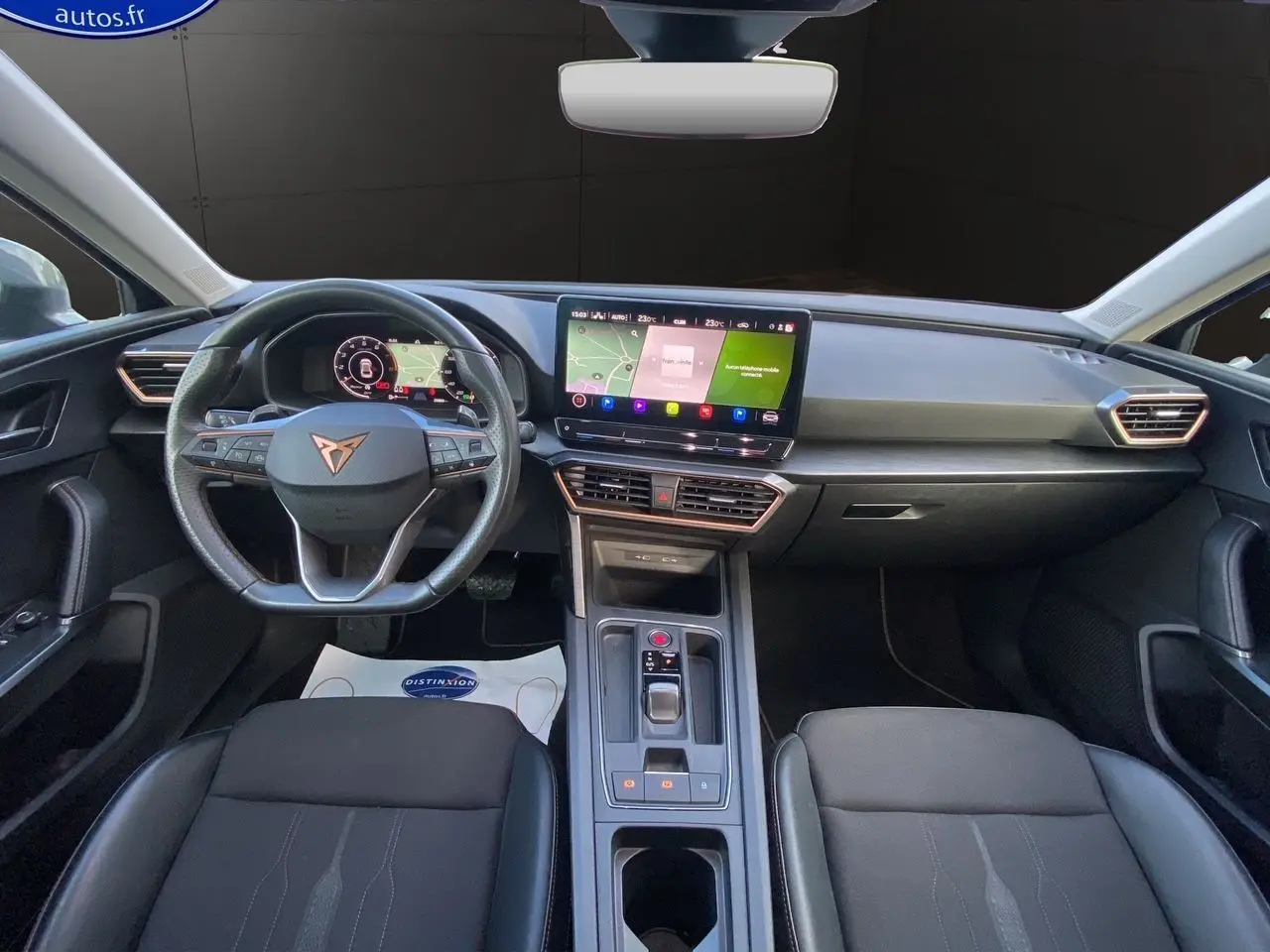 Vue intérieure frontale du tableau de bord et volant noir de la CUPRA Leon 2023 avec écran tactile central et finitions modernes.